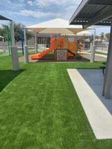 Artificial turf playground with shade structures, freshly installed by Victor's Landscaping in the Phoenix area