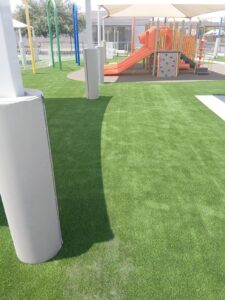 Curved artificial turf bed installed around play-structure posts